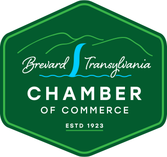 Logo of Brevard Transylvania Chamber of Commerce with a green hexagonal shape, mountain graphics, and a blue river or waterfall icon. The text reads "Brevard Transylvania Chamber of Commerce ESTD 1923.