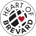 Logo featuring a black circular map pattern with a red heart in the center. The text "Heart of Brevard" curves around the logo's top and bottom edges.