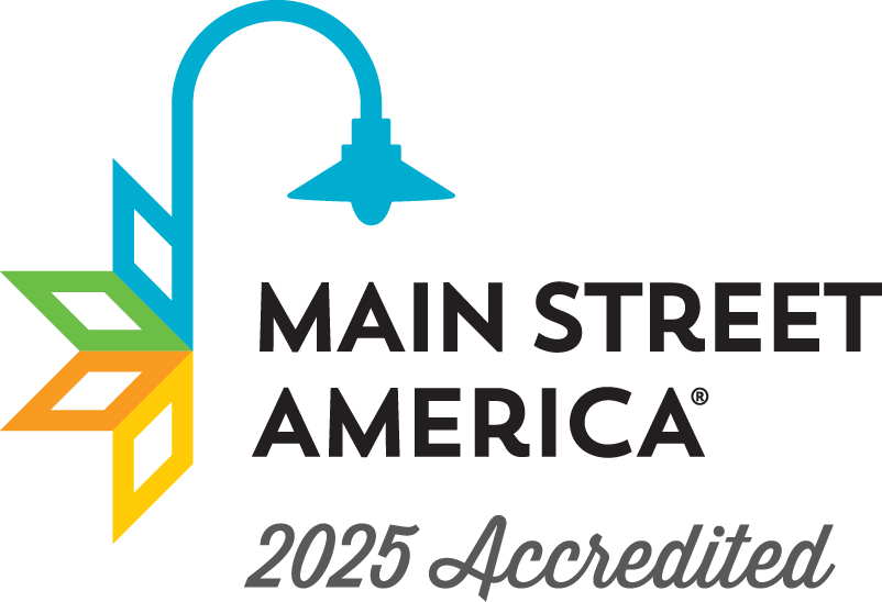 Logo of Main Street America indicating 2024 accreditation. It features a stylized lamp post with geometric leaves in blue, green, orange, and yellow. The text reads "Main Street America" and "2024 Accredited.